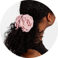 Pink flower-shaped hair clip for women, styled in curly hair – hair clip by SASSYCLASSY