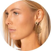 Woman wearing large gold hoop earrings with a delicately textured disc – earrings by SASSYCLASSY