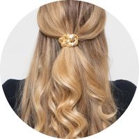 A woman wears a gold hair tie with a chain detail in her half-up hairstyle – hair ties by SASSYCLASSY