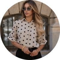 Women's muslin blouse in beige with a black polka-dot pattern, a shirt collar, and three-quarter sleeves, styled with a black skirt – short-sleeved muslin blouses by SASSYCLASSY
