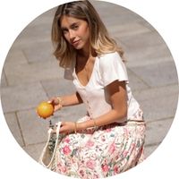 Summery women's outfit: A white short-sleeve blouse paired with a flowing midi skirt featuring a floral pattern in pink and green by SASSYCLASSY