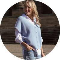 Women's light blue knit vest with a V-neck and button placket, styled with a white shirt and light-colored jeans – vests by SASSYCLASSY